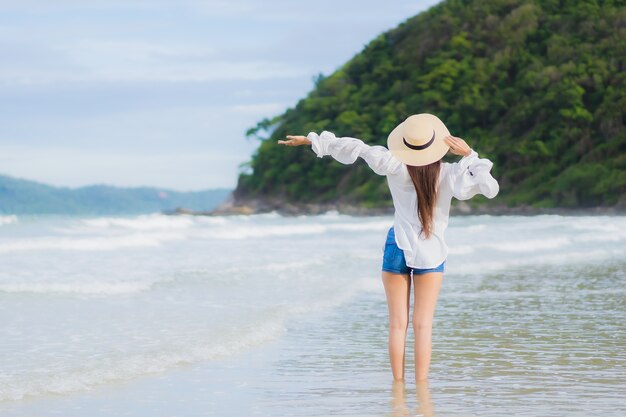 肖像画美しい若いアジアの女性は、休日の休暇旅行旅行でビーチの海の海の周りの笑顔をリラックス