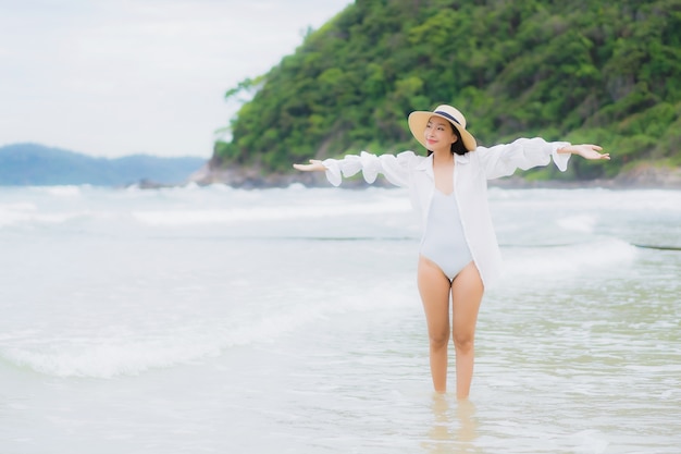 초상화 아름 다운 젊은 아시아 여자 휴가 휴가 여행 여행에서 해변 바다 바다 주위에 미소를 휴식