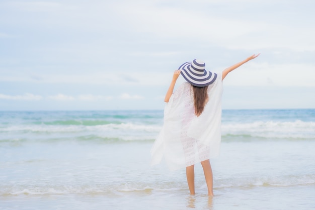 초상화 아름 다운 젊은 아시아 여자 휴가 휴가 여행 여행에서 해변 바다 바다 주위에 미소를 휴식