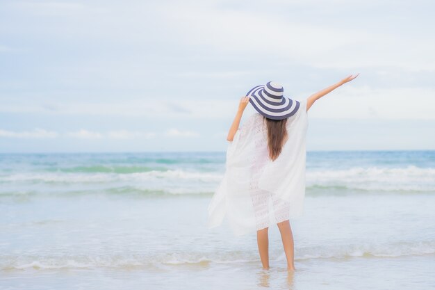 肖像画美しい若いアジアの女性は、休日の休暇旅行旅行でビーチの海の海の周りの笑顔をリラックス