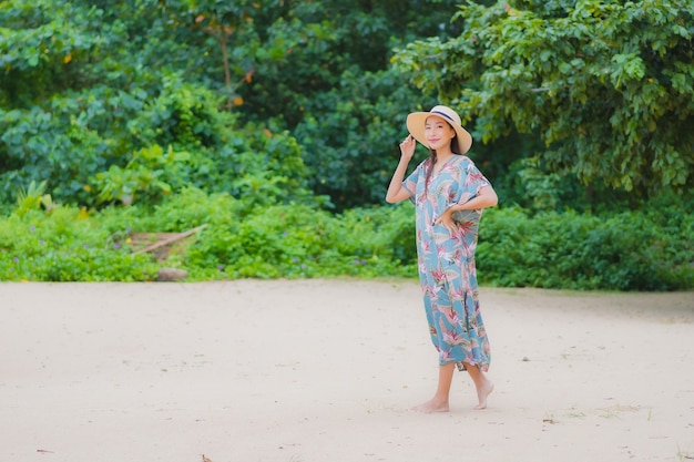 肖像画美しい若いアジアの女性は休日の休暇でビーチの海の海の周りの笑顔をリラックス