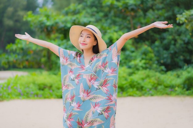 肖像画美しい若いアジアの女性は休日の休暇でビーチの海の海の周りの笑顔をリラックス