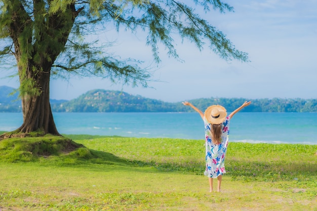 肖像画美しい若いアジアの女性は休日の休暇でビーチの海の海の周りの笑顔をリラックス