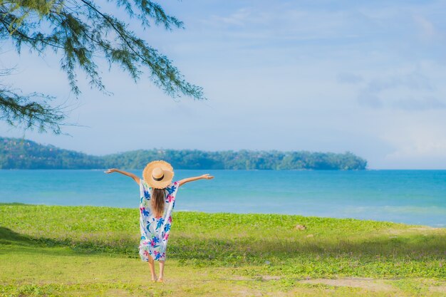 肖像画美しい若いアジアの女性は休日の休暇でビーチの海の海の周りの笑顔をリラックス