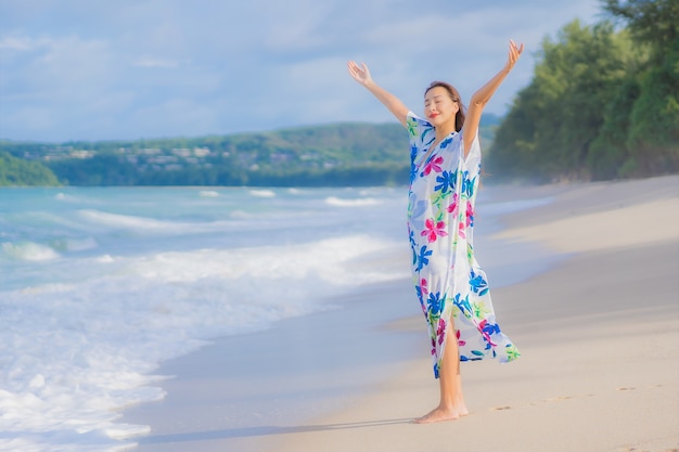 肖像画美しい若いアジアの女性は休日の休暇でビーチの海の海の周りの笑顔をリラックス