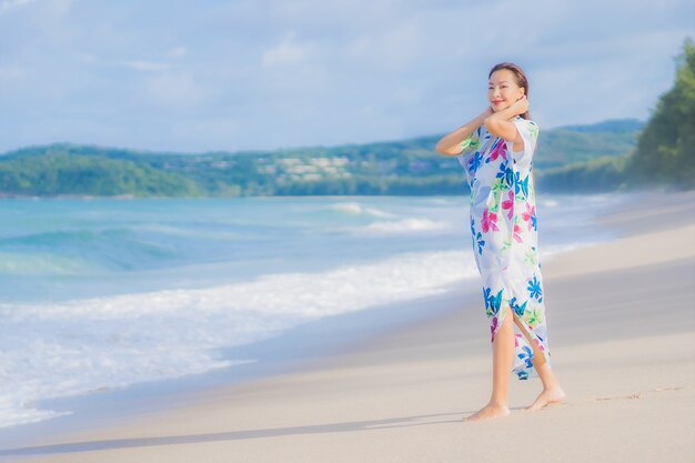 肖像画美しい若いアジアの女性は休日の休暇でビーチの海の海の周りの笑顔をリラックス