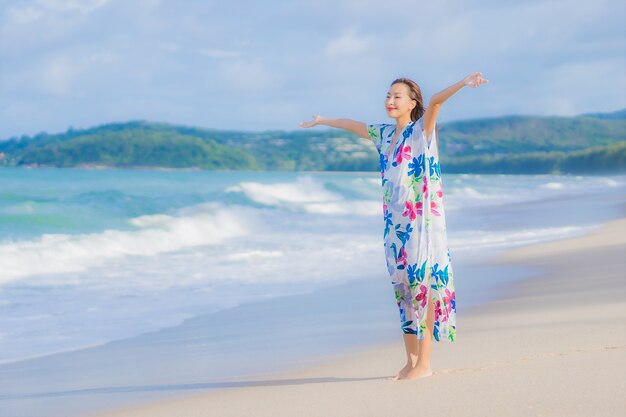 초상화 아름 다운 젊은 아시아 여자는 휴가 휴가에 해변 바다 바다 주위에 미소를 휴식