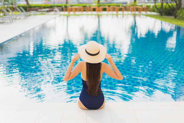 Free photo portrait beautiful young asian woman relax smile around outdoor swimming pool in hotel resort in vacation travel