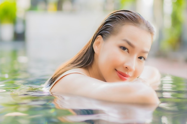 Portrait beautiful young asian woman relax smile around outdoor swimming pool in hotel resort on vacation travel