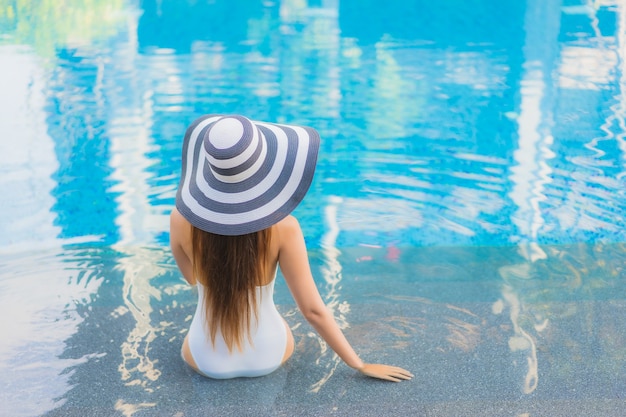 Portrait beautiful young asian woman relax smile around outdoor swimming pool in hotel resort