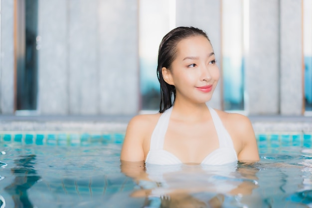 Portrait beautiful young asian woman relax smile around swimming pool in hotel resort on traval vacation