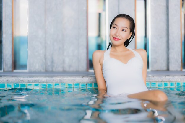 Portrait beautiful young asian woman relax smile around swimming pool in hotel resort on traval vacation