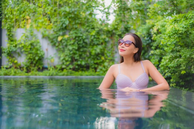 Portrait beautiful young asian woman relax smile leisure around outdoor swimming pool in hotel resort