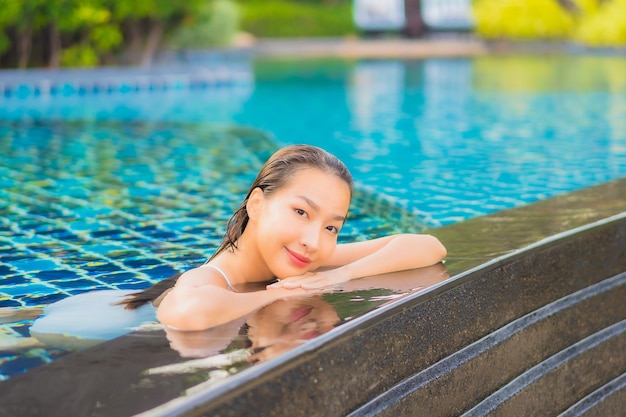 Portrait beautiful young asian woman relax smile leisure around outdoor swimming pool nearly sea