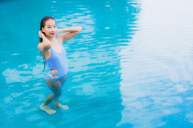 세로 아름 다운 젊은 아시아 여자 야외 수영장 주변 미소 레저 휴식