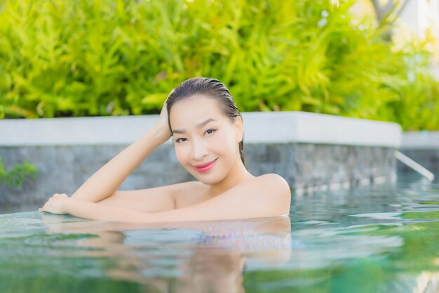 세로 아름 다운 젊은 아시아 여자 야외 수영장 주변 미소 레저 휴식