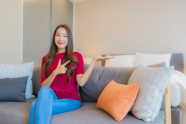 Portrait beautiful young asian woman relax smile on sofa in living area