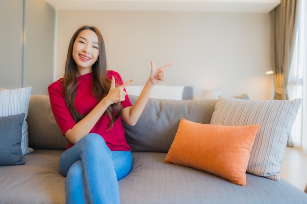 Foto gratuita la bella giovane donna asiatica del ritratto si rilassa il sorriso sul sofà nella zona vivente