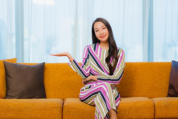 Portrait beautiful young asian woman relax on sofa in living room interior