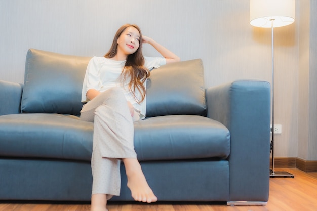 Portrait beautiful young asian woman relax on sofa in living room interior