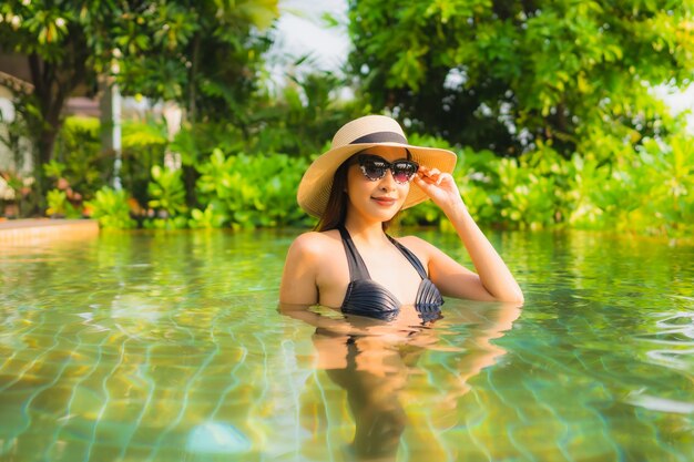 세로 아름 다운 젊은 아시아 여자 레저 휴가 호텔 리조트 수영장에서 휴식