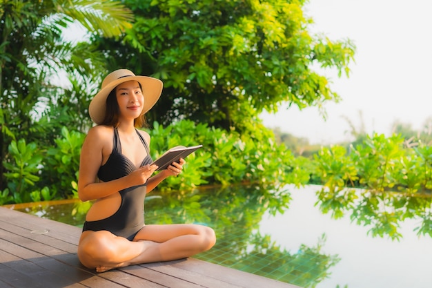 세로 아름 다운 젊은 아시아 여자 레저 휴가 호텔 리조트 수영장에서 휴식