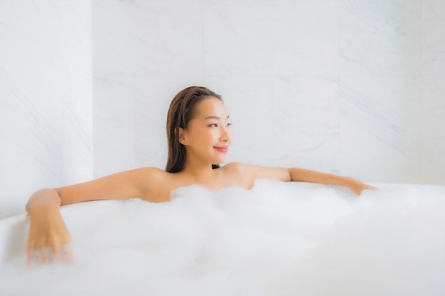 美しい若いアジアの女性の肖像画は浴槽でリラックス