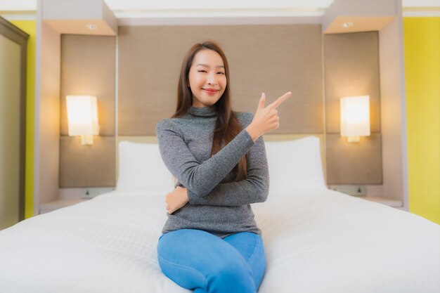 아름 다운 젊은 아시아 여자의 초상화는 침실에서 침대에 이완