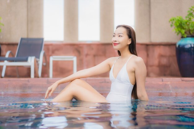 아름 다운 젊은 아시아 여자의 초상화는 수영장에서 이완
