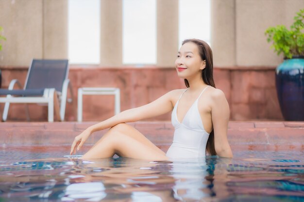 Portrait of beautiful young asian woman relaxes in the pool