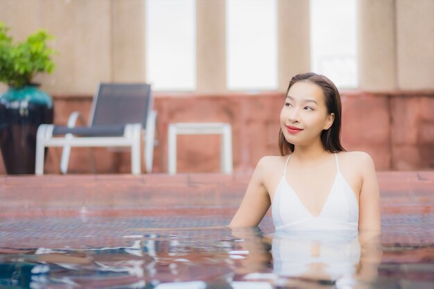 아름 다운 젊은 아시아 여자의 초상화는 수영장에서 이완