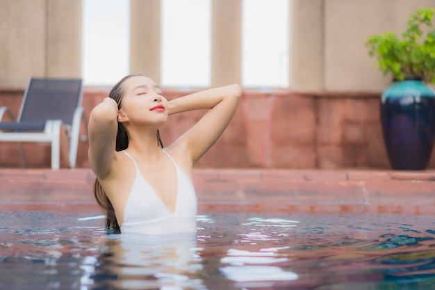 Portrait of beautiful young asian woman relaxes in the pool