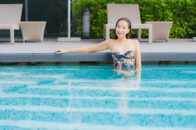 아름 다운 젊은 아시아 여자의 초상화는 호텔 리조트의 수영장에서 이완