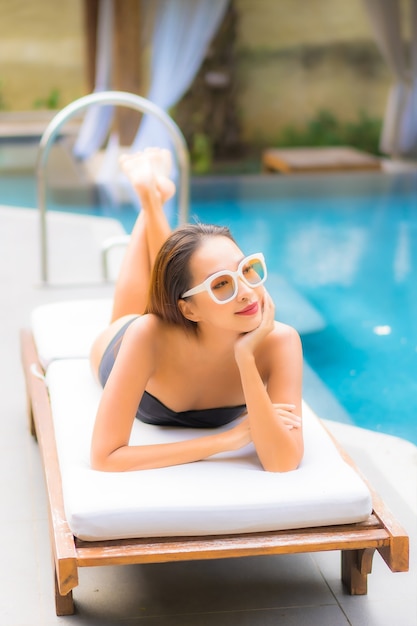 Portrait of beautiful young asian woman relaxes in the swimming pool