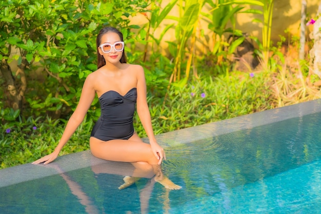 Portrait of beautiful young asian woman relaxes in the swimming pool