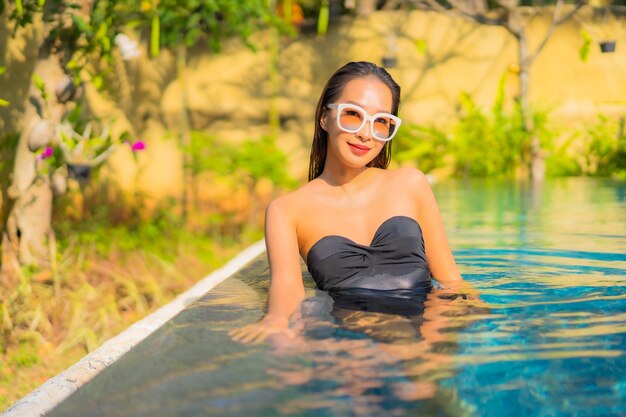 Portrait of beautiful young asian woman relaxes in the swimming pool