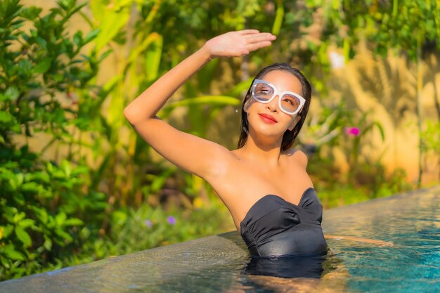 Portrait of beautiful young asian woman relaxes in the swimming pool