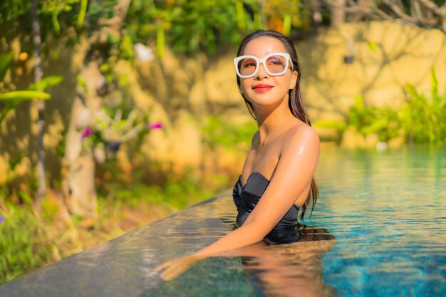 Portrait of beautiful young asian woman relaxes in the swimming pool