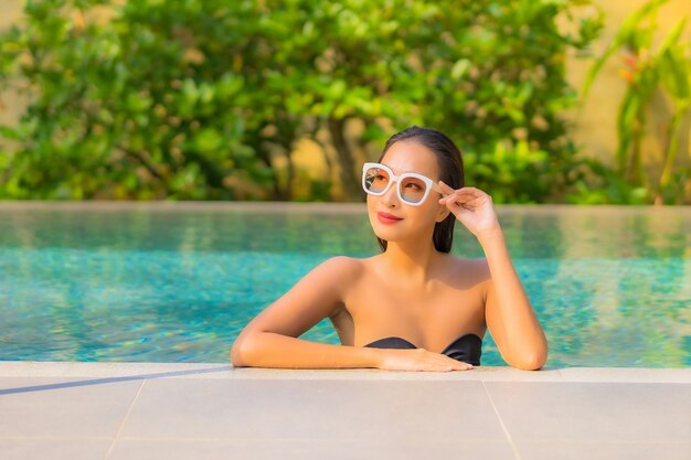 Portrait of beautiful young asian woman relaxes in the swimming pool