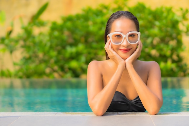 Portrait of beautiful young asian woman relaxes in the swimming pool