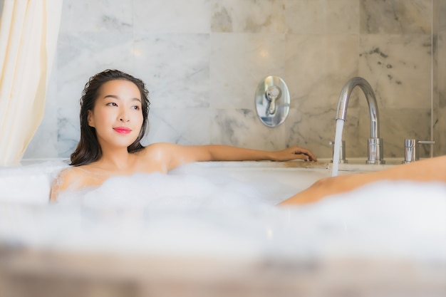 Женщина портрета красивая молодая азиатская ослабляет принимает ванну