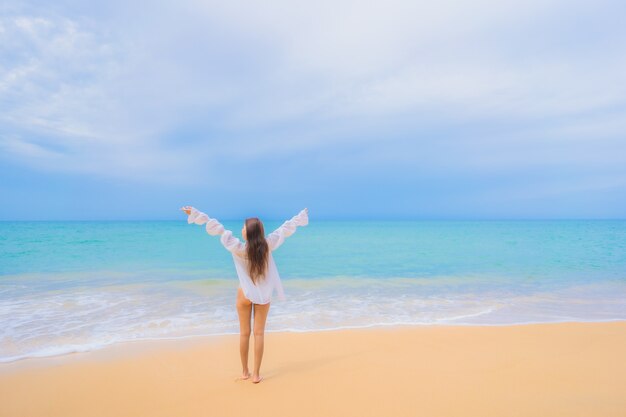 旅行休暇でビーチの海の海の周りでリラックスした美しい若いアジアの女性の肖像画