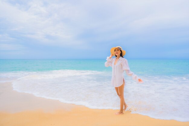 旅行休暇でビーチの海の海の周りでリラックスした美しい若いアジアの女性の肖像画