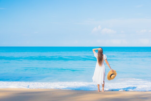여행 휴가에 푸른 하늘에 흰 구름과 해변 주변에서 편안한 아름 다운 젊은 아시아 여자의 초상화