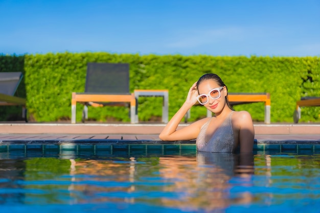 Portrait of beautiful young asian woman relaxing around outdoor swimming pool in hotel resort