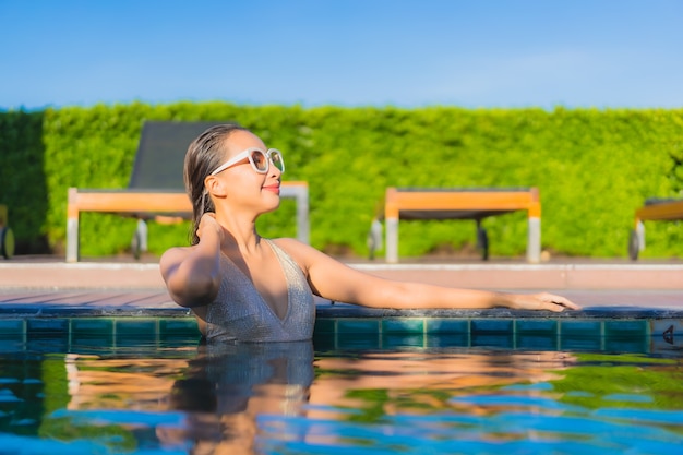 Portrait of beautiful young asian woman relaxing around outdoor swimming pool in hotel resort