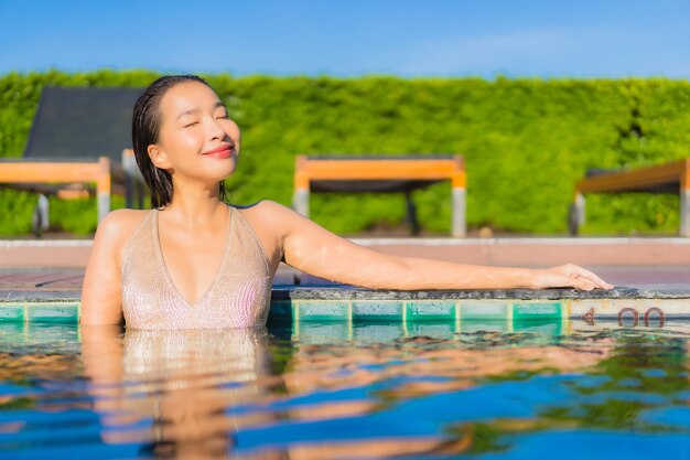 호텔 리조트에서 야외 수영장 주변에서 편안한 아름 다운 젊은 아시아 여자의 초상화