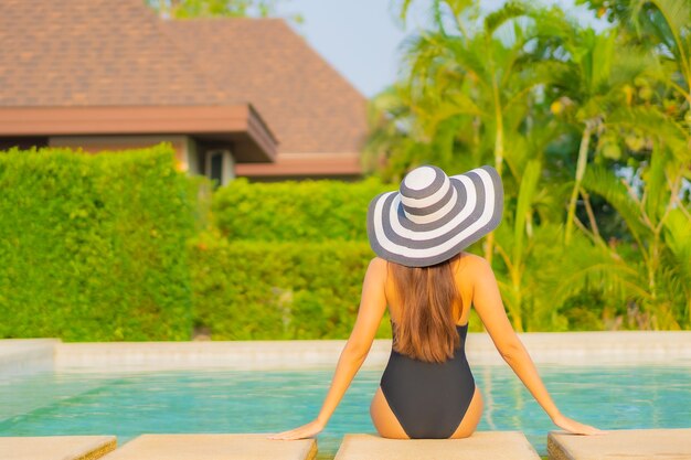 Portrait beautiful young asian woman relaxing around swimming pool in resort hotel on vacation