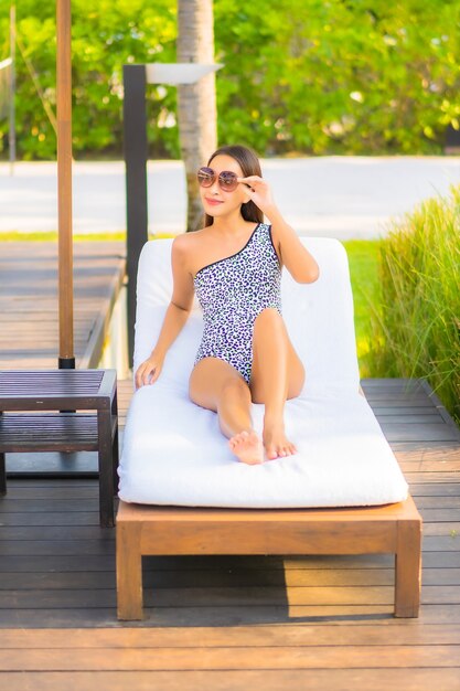 Portrait beautiful young asian woman relaxing around swimming pool in resort hotel on vacation