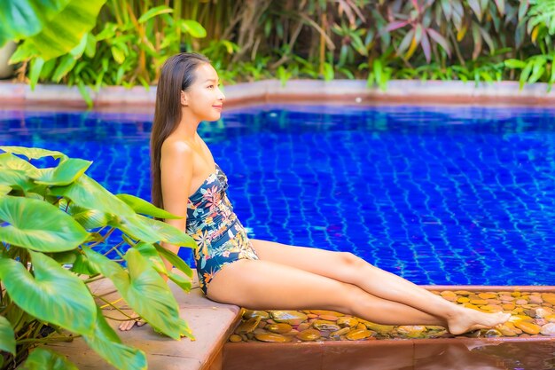 Portrait beautiful young asian woman relaxing around swimming pool in resort hotel on vacation